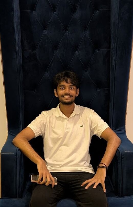 Heshan Jayakody smiling in a high-back chair